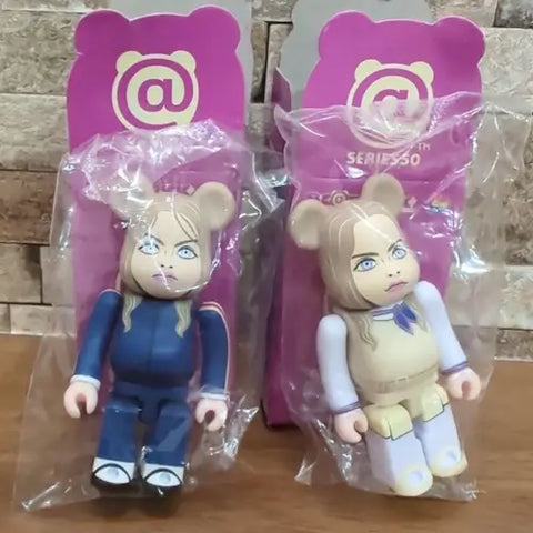 BE@RBRICK Series 50 M3GAN Secret-Figur - Vergleich zwischen offizieller M3GAN in blauem Outfit und Secret-Version in cremefarbenem Kostüm aus M3GAN 2.0